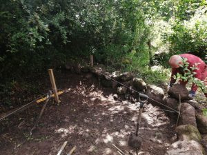 Kevin building a wall out of granite boulders