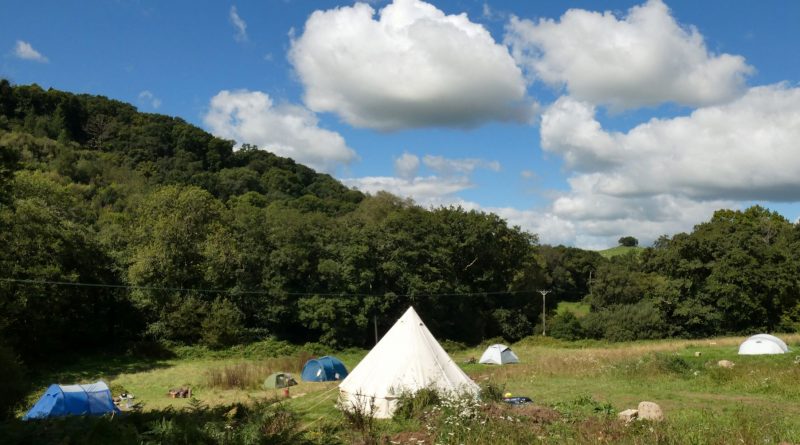 View of Hay Meadow camping field with blue sky and clouds