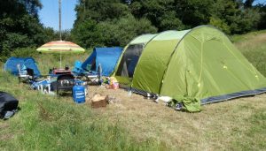 Nearly Wild in the Hay Meadow crammed with 3 tents (1 large, 1 medium and 1 small), tables chairs