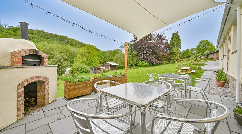 View of the garden from the patio just outside the twin room. Showing pizza oven and bistro tables and chairs