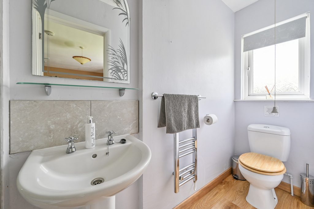 Double room en suite showing toilet, pedastal wash basin and towel heater