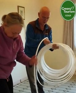 Michelle and Kevin laying the underfloor heating pipe into the pre-routed flooring.