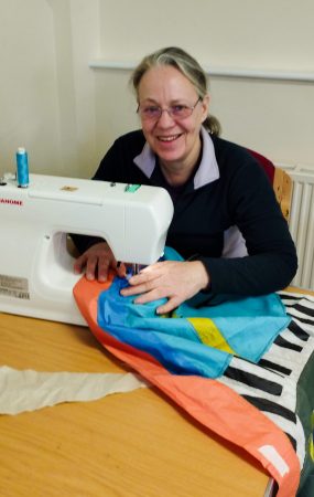 Michelle repairing a brightly coloured flag