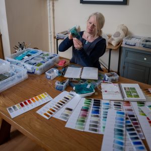 Artist posing with her glass pendants in her studio