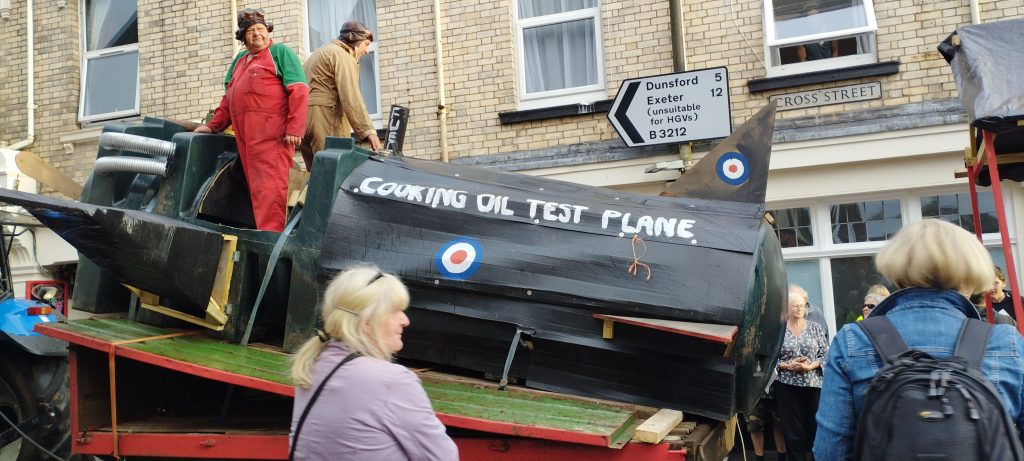 Entertaining float in the carnival procession.  The Royal Frying Corp.  A biplane made from two old oil tanks with folding wings to get through the streets.  The words "Cooking Oil Test Plane" on the side