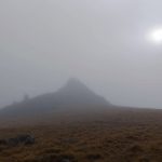 Dartmoor Tor in the fog. Sun shining dimly