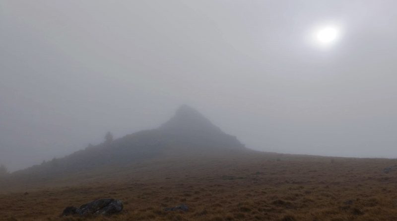 Dartmoor Tor in the fog. Sun shining dimly