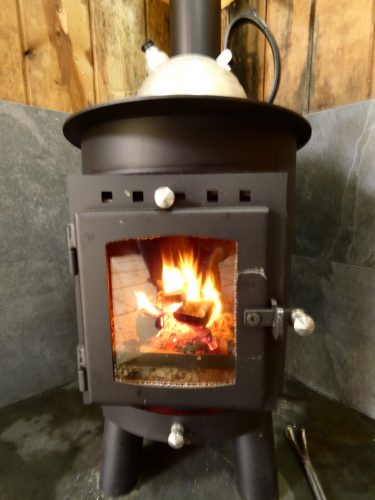 Lit log burner with kettle