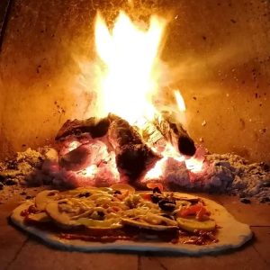 pizza cooking in woodfired pizza oven